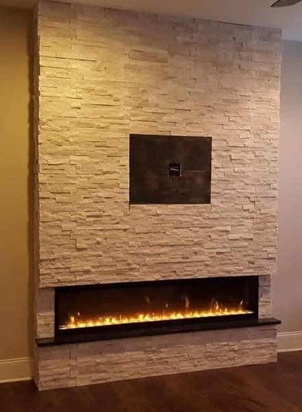 Modern stacked stone fireplace wall with glowing electric flame insert